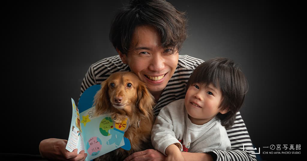 父親と犬と男の子の家族写真